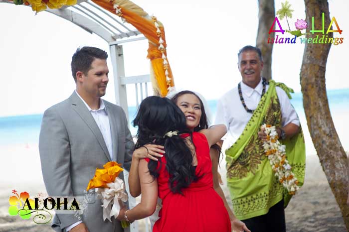 Bride hugging her sister with Reverend Mike Nelson beside them